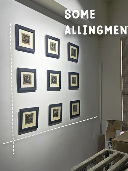 The final touches are all about precision. Here, we're ensuring the gallery wall is perfectly aligned. It's these small details that make a big difference in the final look.