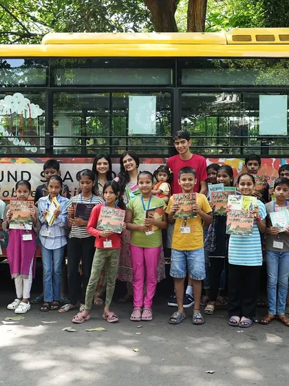 The whole group, including students and volunteers, posing proudly in front of the Sound Space on Wheels bus.