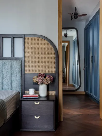 Details matter in creating a personal sanctuary. In this bedroom, we combined a custom headboard with rattan accents and a sleek bedside table, layering textures to add warmth and character to the space.