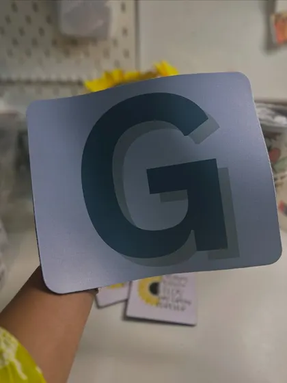 A custom mousepad with a bold initial 'G'. A simple yet effective way to personalize your desk setup.