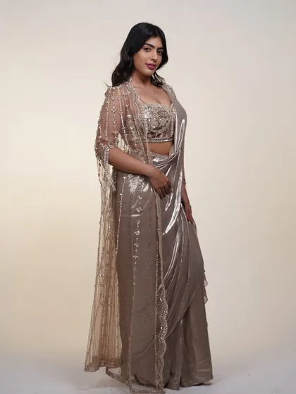 This metallic saree comes with a beautifully embroidered cape, adding a layer of elegance and drama. It's a complete look that's ready for any grand entrance.