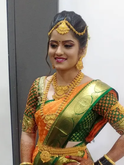 This bride is glowing in her orange silk saree. I used a warm, golden-toned makeup palette to complement her skin tone and the rich colors of her wedding attire, complete with a traditional waist belt.
