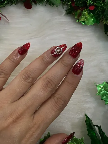 A single-hand shot to show the detail of the diamond snowflake accent nail against the glittery red.
