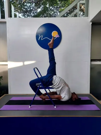 Here, a chair is used to practice a variation of Eka Pada Viparita Dandasana. This prop-assisted backbend helps to open the shoulders and thoracic spine safely and effectively.