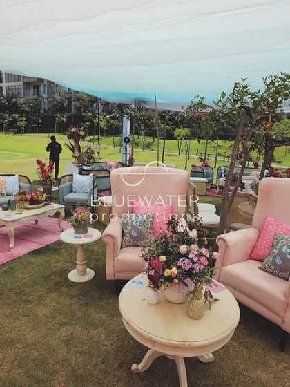 An eclectic mix of furniture, from pink armchairs to cane-backed sofas, creates a layered and interesting lounge for a welcome lunch.