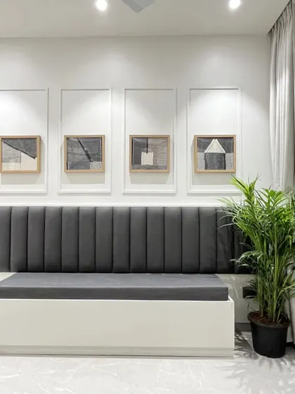 A dining area with a long, dark grey upholstered bench seat, perfect for maximizing seating in a modern space.