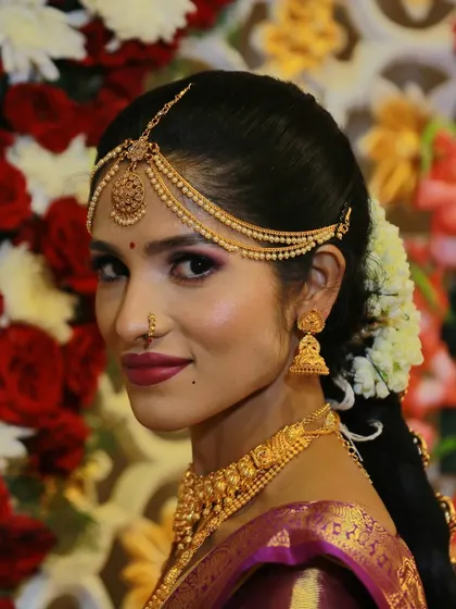 A beautiful bridal portrait against a floral backdrop, showcasing the bride's complete look.