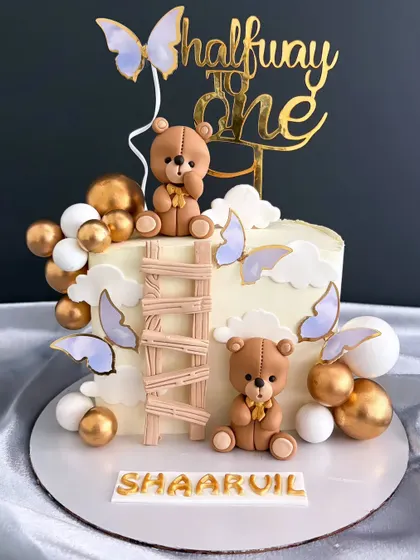 Another view of the sweet "Halfway to One" teddy bear cake, showing the golden and white balloon accents.