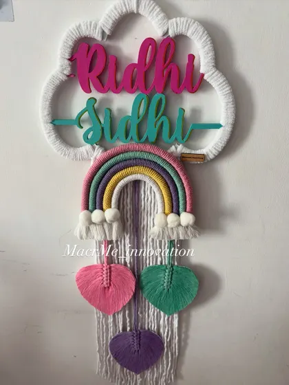 This double name hanging for Riddhi and Sidhi uses a lovely pastel palette with pink, green, and purple heart-shaped leaves. It's a sweet and coordinated piece for a shared room.