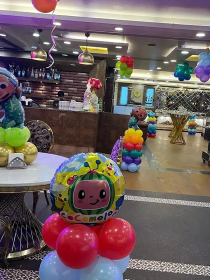 Another view of the Cocomelon table centerpieces and hanging balloon bunches that filled the party hall.