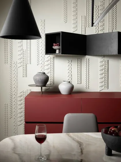 A close-up of the dining area shows how we infused the space with warmth and personality. The cherry red sideboard and custom wall paneling create a seamless transition from the kitchen, making this a perfect spot for everything from casual meals to formal entertaining.