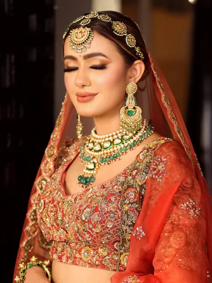 Eyes closed, the artistry shines through. This shot highlights the seamless eyeshadow blending and the soft, peachy tones that complement the bride's complexion.