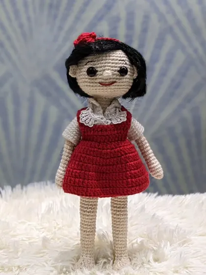 A full-length view of the custom doll in the red dress, showing the complete handmade creation.