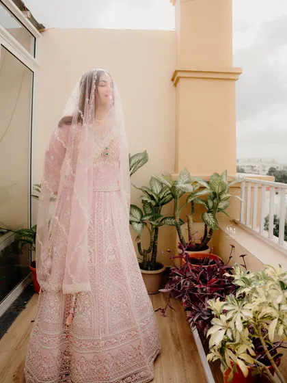 A candid shot of the bride on a balcony, her veil flowing in the breeze. This photo feels natural, happy, and full of life.