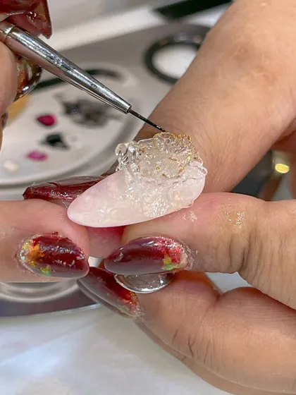 An artist at work during a seminar, sculpting a complex 3D design with clear molding gel.