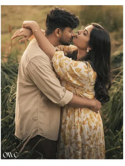 A passionate kiss shared by a couple in a field, a beautiful and romantic highlight from their pre-wedding session.