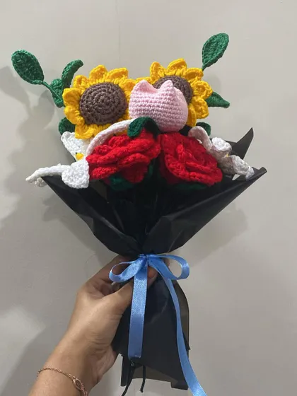 Holding the mixed bouquet of sunflowers, roses, and lilies. The blue ribbon adds a nice pop of color against the black wrapping.