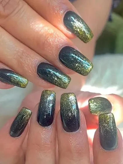 A beautiful black and gold glitter ombré on square-shaped nails, creating a glamorous and sophisticated look.