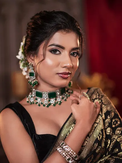 A close-up of the simple and elegant makeup look, focusing on the clean eyeliner and glossy lips that complement the heavy jewelry.