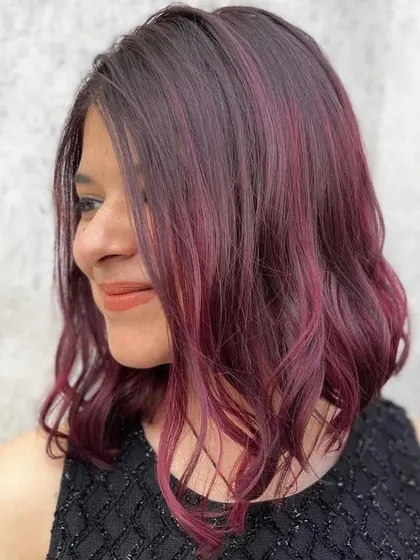 A gorgeous flowing wine hair color. This rich, violet-red shade is perfect for clients wanting a bold but elegant transformation.