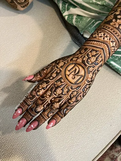 A close-up of the 'RM' initial design. The surrounding floral pattern is dense and intricate, making the initials pop.