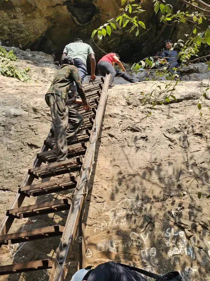 Another view of the group climbing the ladder into the caves.