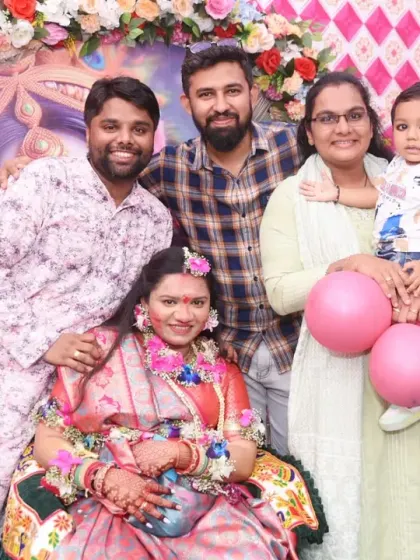 Friends and family gather around the mom-to-be for a happy group photo at the baby shower.