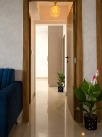 A simple and elegant hallway with wooden doors and potted plants, showing our attention to even the transitional spaces in a home.