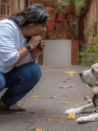 A candid moment of a pet parent interacting with her senior labrador, showing the patience and love involved in a shoot.
