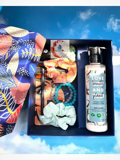 A self-care package for her, beautifully arranged in a blue box. This hamper contains Love Beauty and Planet body lotion, scrunchies, bracelets, and other accessories.