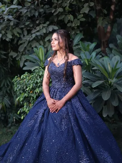 A candid moment in a beautiful outdoor setting. The natural-looking makeup complements the daytime lighting and the lush green background.
