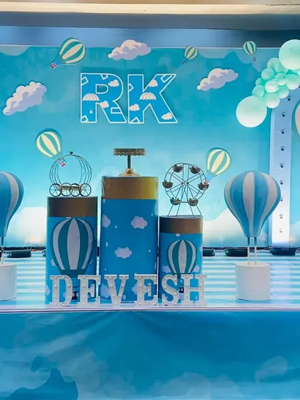 The main stage for the hot air balloon party, with themed pedestals, props, and a personalized backdrop.