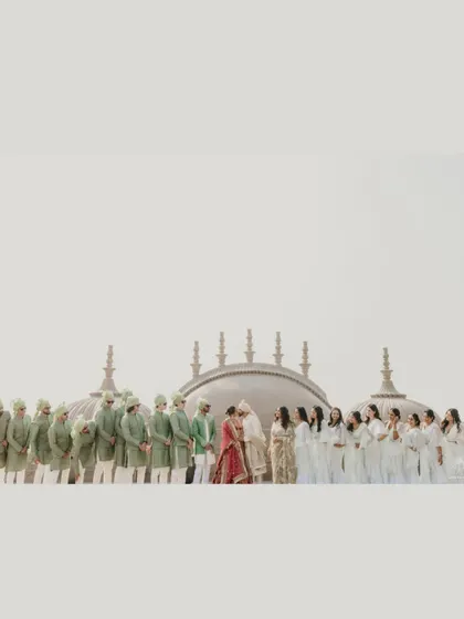 A wide shot of the couple and their wedding party, creating a beautiful, symmetrical line of color and celebration. This image captures the scale and joy of their big day.