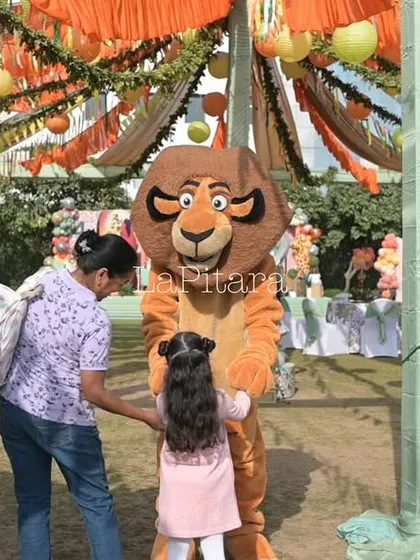 A candid moment from the Lion King party, where a young guest interacts with a character mascot. I focus on creating an engaging experience for everyone.