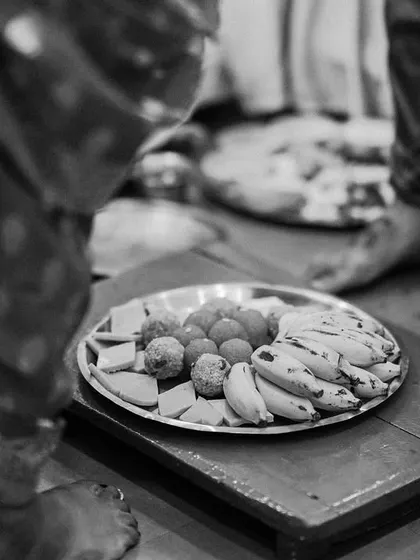 A black and white photo capturing the traditional offerings of fruits and sweets that are part of the wedding rituals.