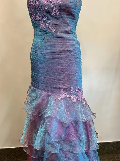 This iridescent bodycon dress is a unique rental piece. The color shifts between blue and purple, and the ruffled mermaid-style bottom adds a touch of flair.