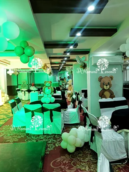 The teddy bear theme is extended to the guest seating, with themed chair covers and small balloon arrangements on the tables.