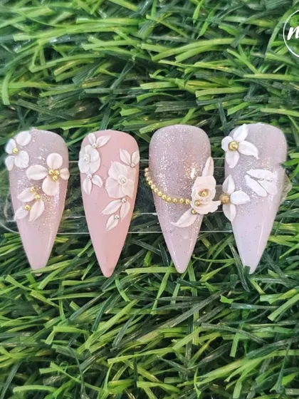 I love seeing my students master advanced techniques. This set of 3D white floral nails on a shimmery base is elegant and expertly crafted.