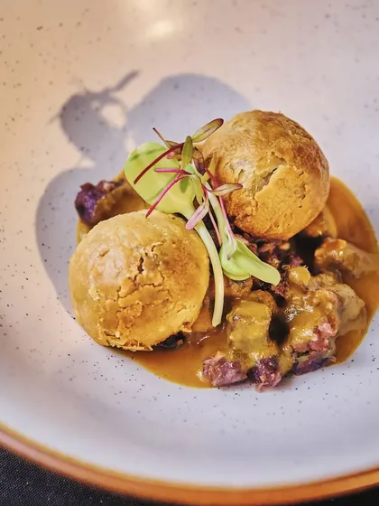A modern take on a Bihari classic. This dish features Feta and Amaranth Puff "Litti" served on a bed of purple potato chokha and drizzled with ghee from Begum Victoria Cheese.
