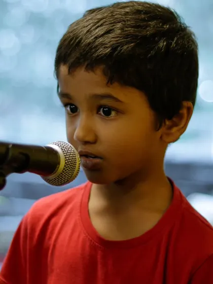 A close-up of a young vocalist at the Summer Camp Recital. It's amazing to see their confidence grow in such a short time.