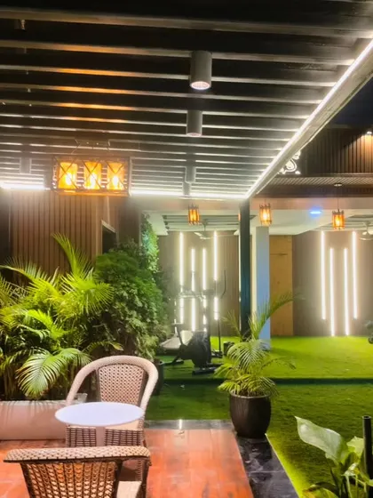 An evening shot of the Model Town terrace, highlighting the vertical LED tube lights and pendant lamps that create a dramatic and modern atmosphere.