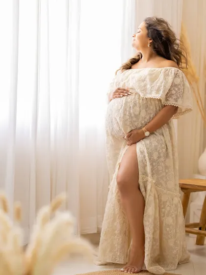 A beautiful solo portrait from a bohemian-themed session, with the mom-to-be basking in the soft window light.
