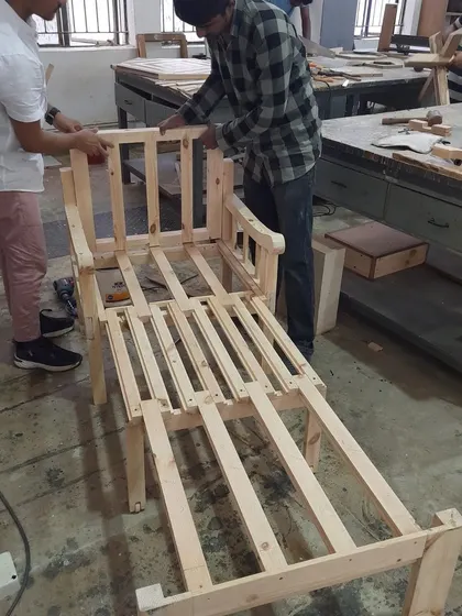 The frame of a lounge chair takes shape. This image shows the complex joinery and assembly required to build sturdy and comfortable seating.