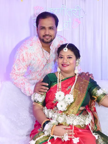 A beautiful posed portrait of the couple, with the husband standing behind his seated wife.