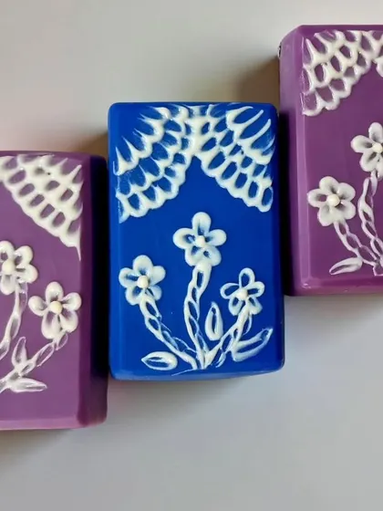 The final result of my brush embroidery soap challenge entry, with delicate white piping on blue and purple bars.