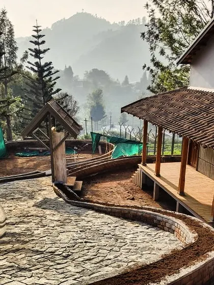 The TARA resort taking shape against the backdrop of the Nilgiri hills. This image captures the raw beauty of the construction process and the stunning natural context.