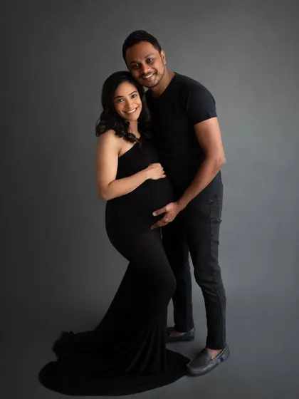 The elegance of a classic maternity portrait. This couple, dressed in all black against a simple grey backdrop, creates a sophisticated and powerful image.