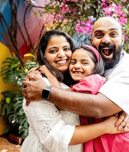 A big, happy family hug! This photo radiates so much energy and love. It's a perfect example of a candid family portrait that is full of life and personality.