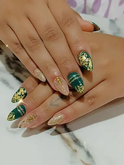 An elegant combination of emerald green and nude nails, adorned with gold glitter and delicate gold foil accents.