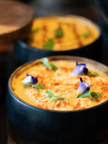 A creamy, rich dip garnished with edible flowers and spices. This dish brings the comforting, authentic flavors of India to a wedding celebration in a refined and beautiful way.